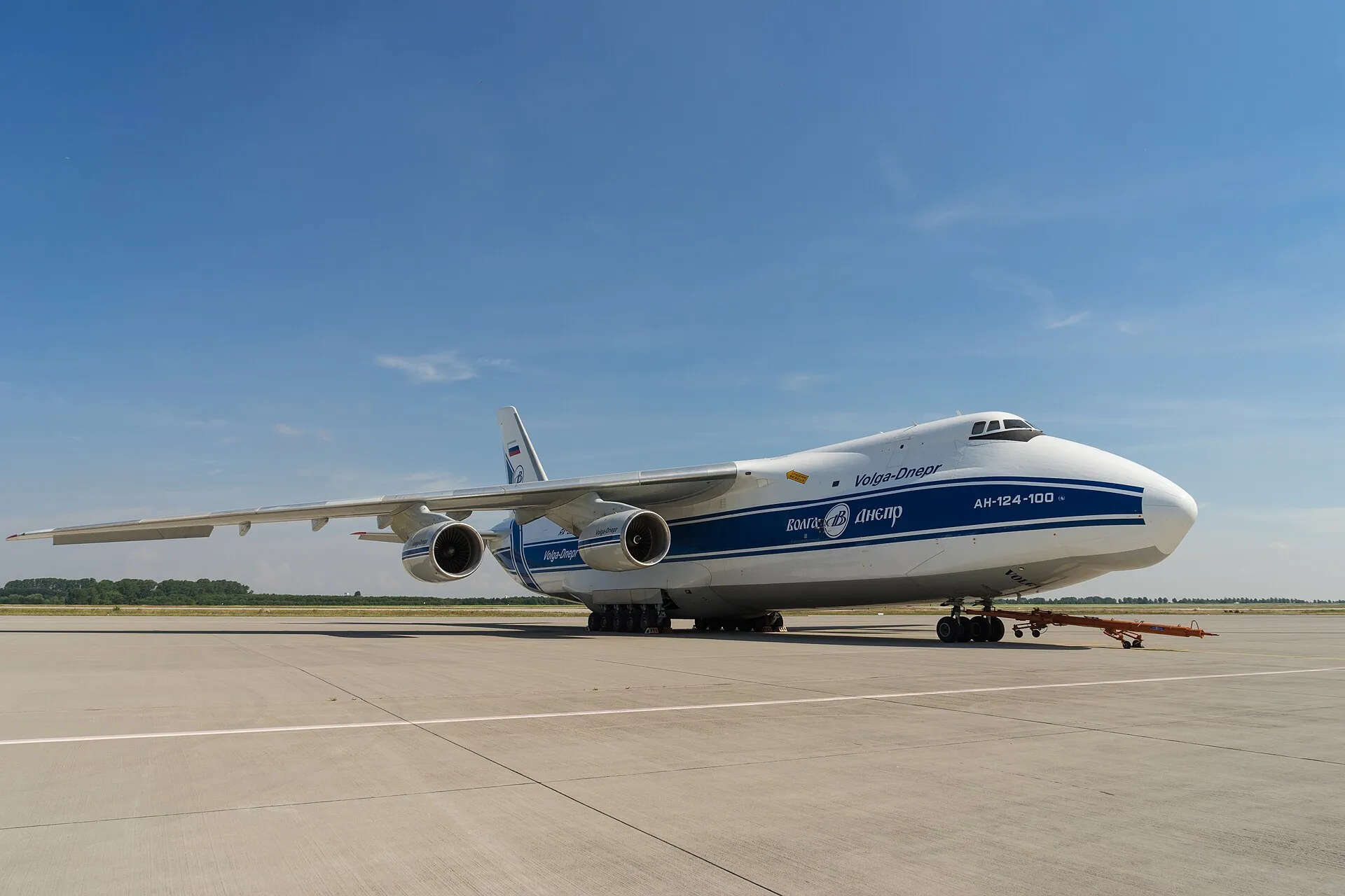 Weiße Antonov An-124-100 auf einem Rollfeld unter blauem Himmel