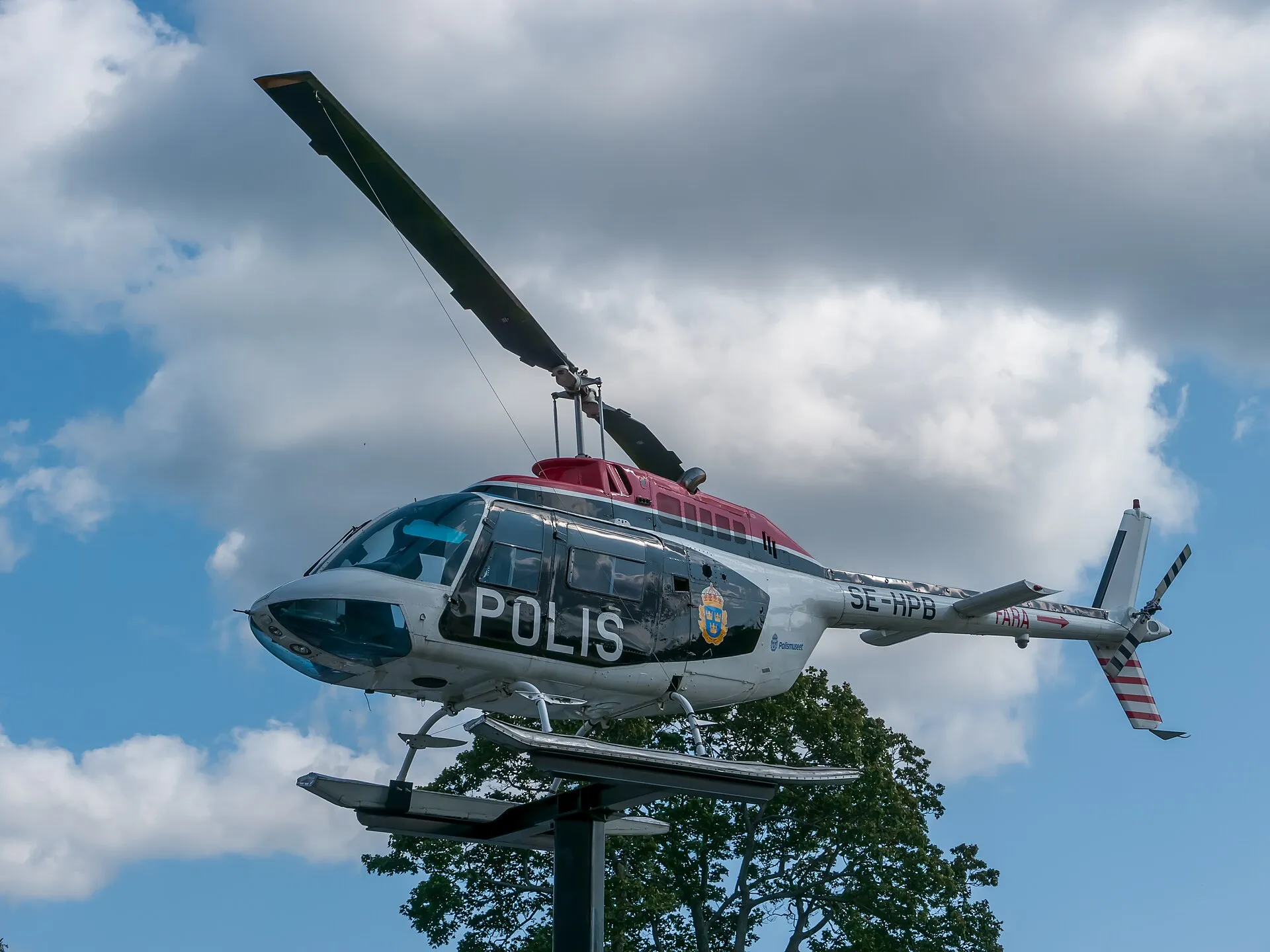 Auf einem Sockel ausgestellter Bell 206B mit schwedischer Polizeibeschriftung.