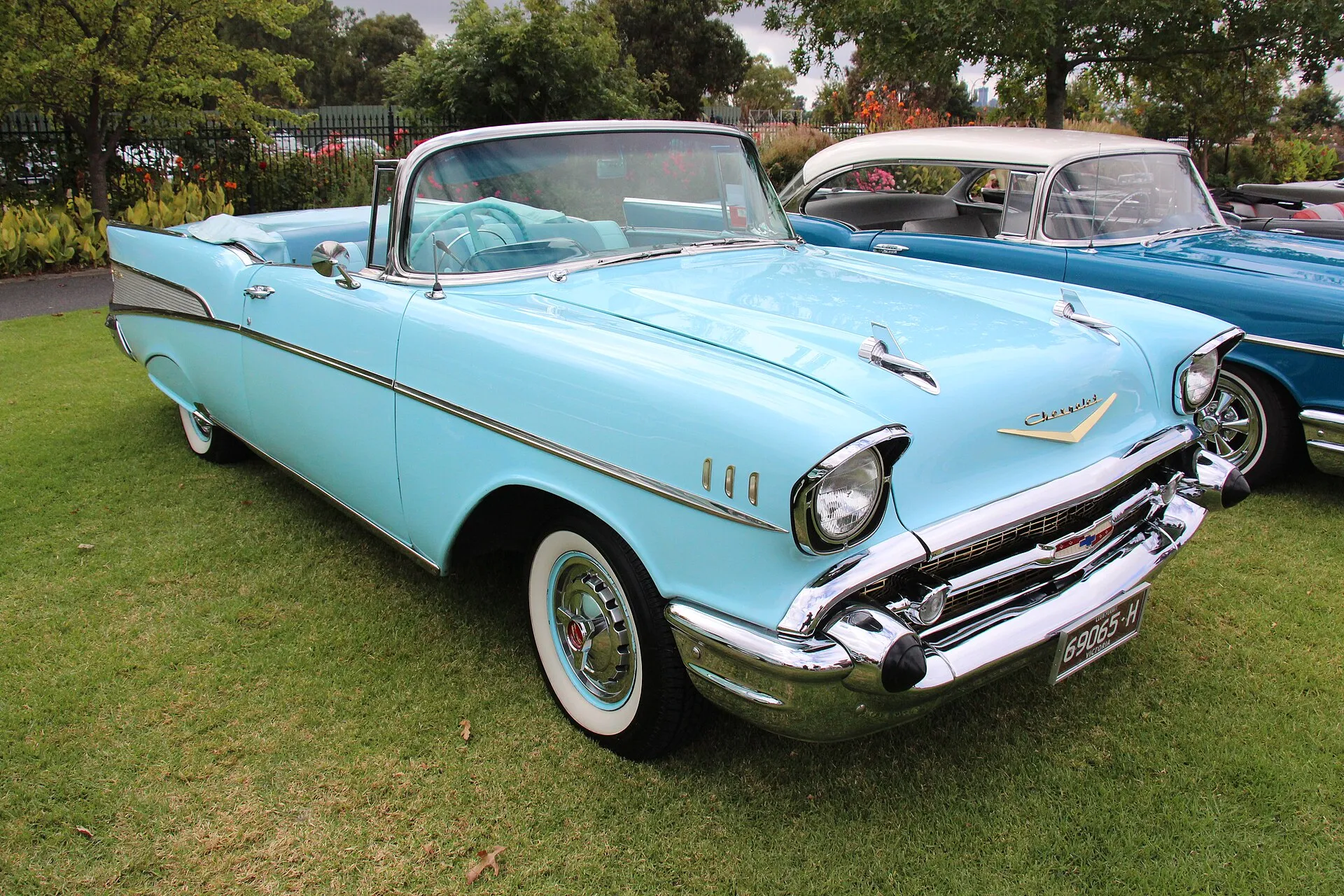 Hellblaues Chevrolet Bel Air Cabriolet von 1957 mit Weißwandreifen auf einer Wiese bei einem Oldtimertreffen
