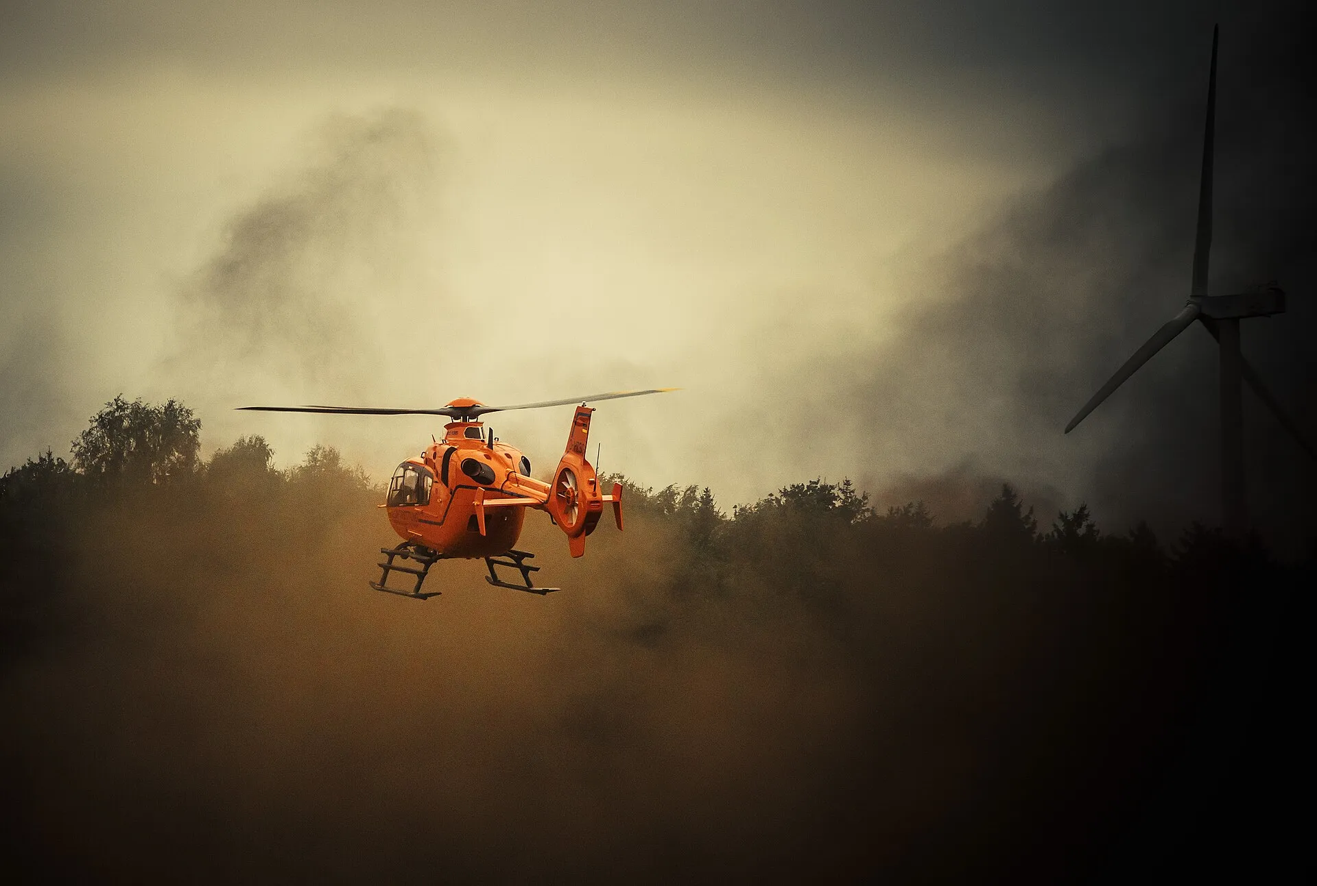 Eurocopter EC135 im Schwebeflug über aufgewirbeltem Staub
