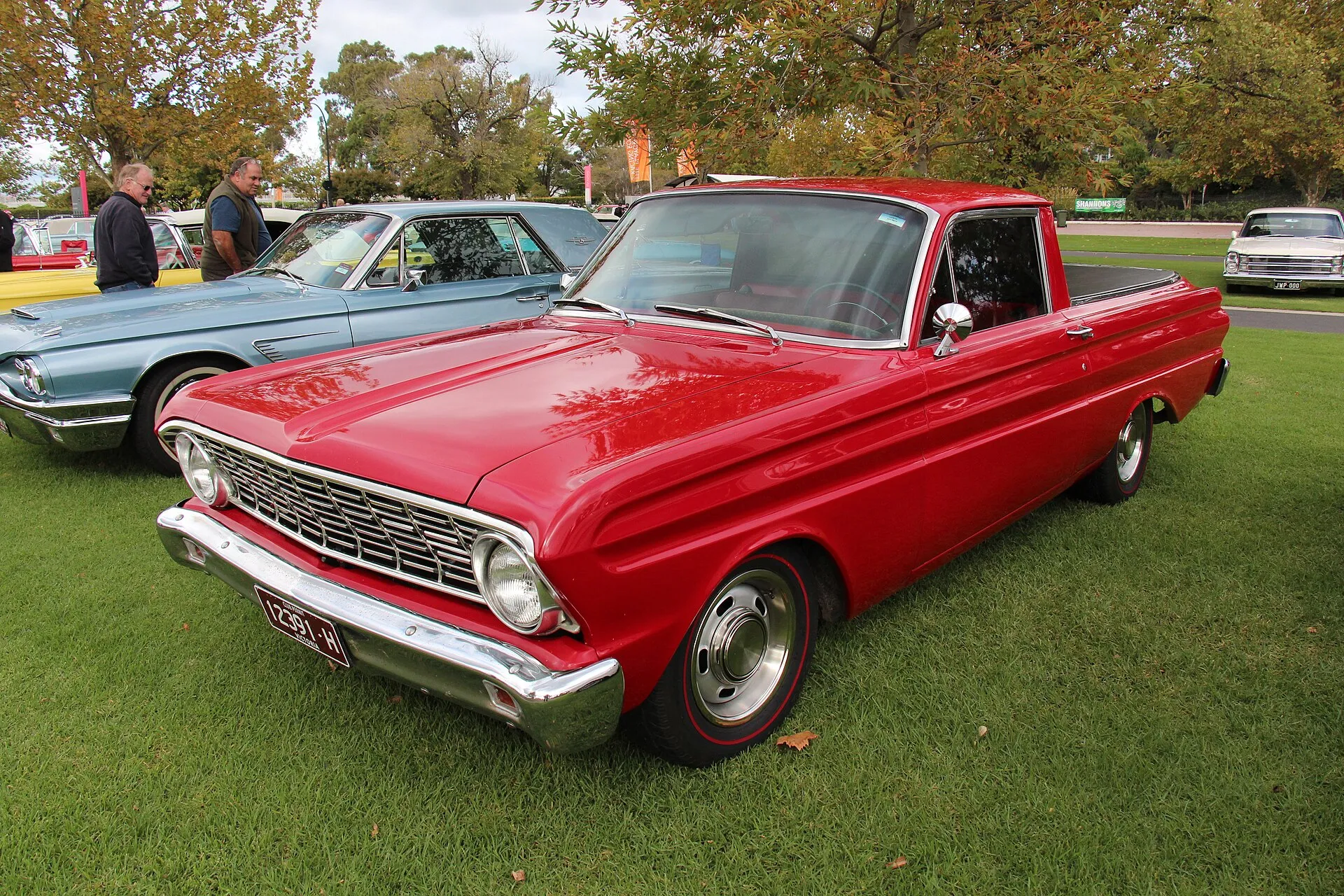 Roter Ford Falcon Ranchero von 1964 auf einer Wiese bei einem Oldtimertreffen