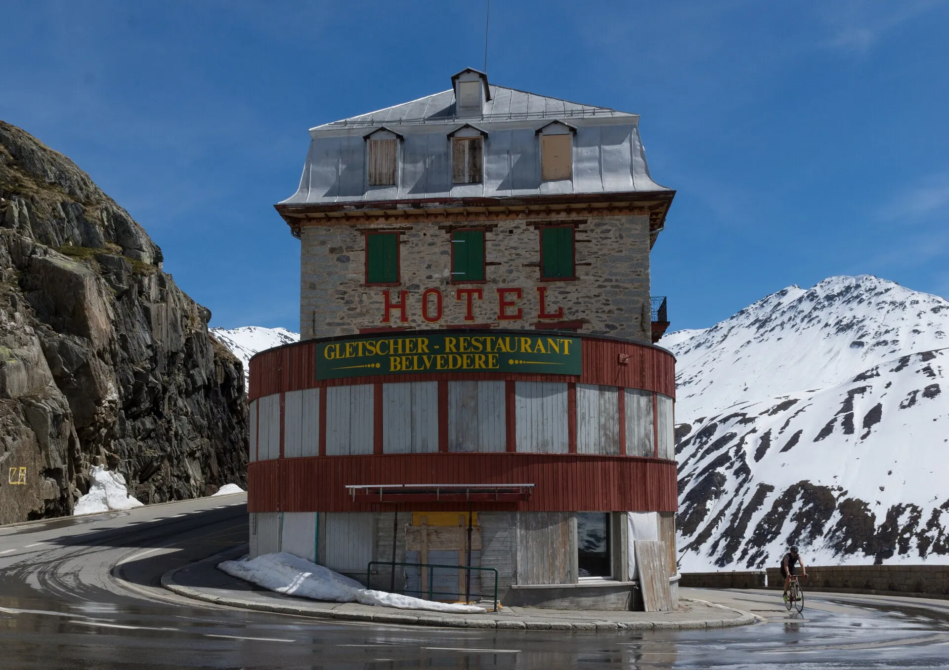 Das leerstehende Hotel Belvédère in der Haarnadelkurve der Furkapassstrasse vor verschneiten Bergen