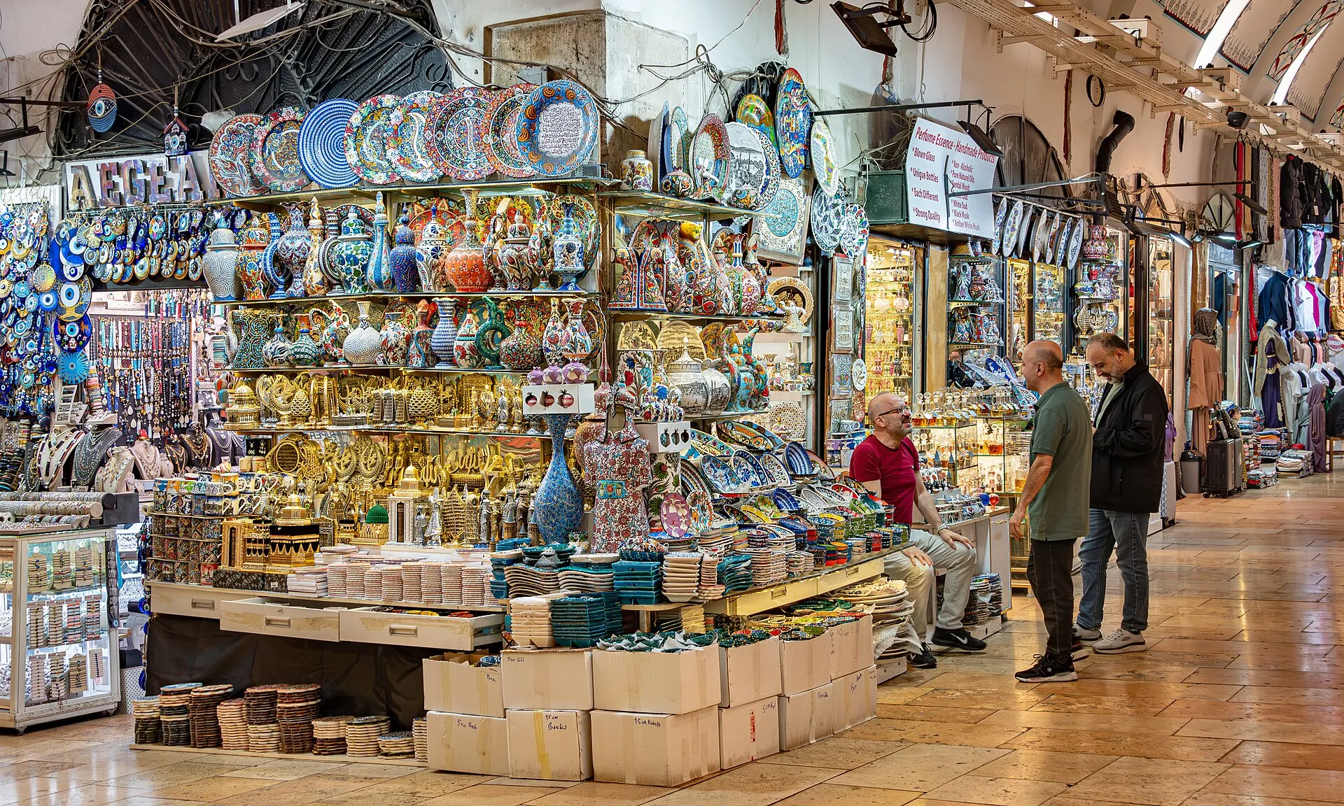 Überwölbte Ladengasse im Großen Basar von Istanbul mit Ständen voller Keramik und Schmuck