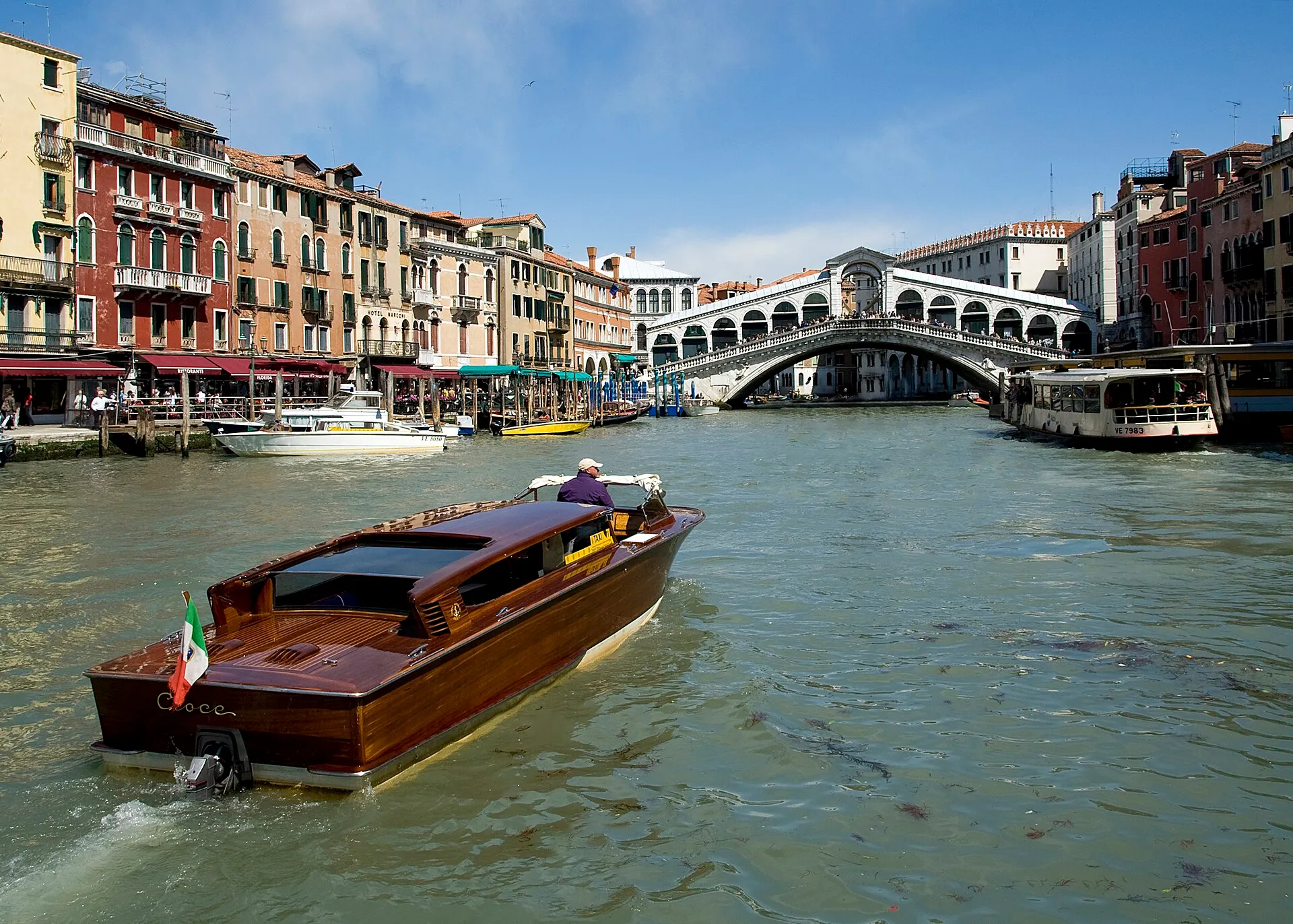 Blick über den Canal Grande auf die Rialtobrücke und ein hölzernes Motorboot
