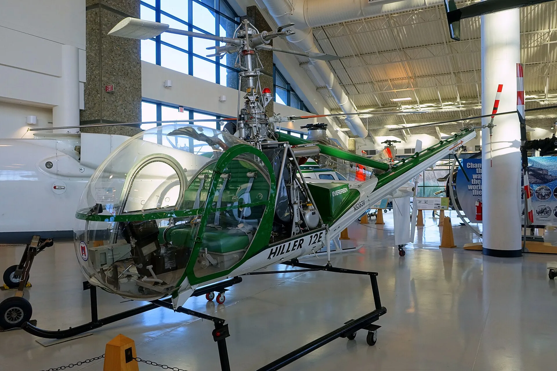 Grün-weißer Hubschrauber Hiller UH-12E mit Glaskanzel und Gitterrohrheck in einer Museumshalle