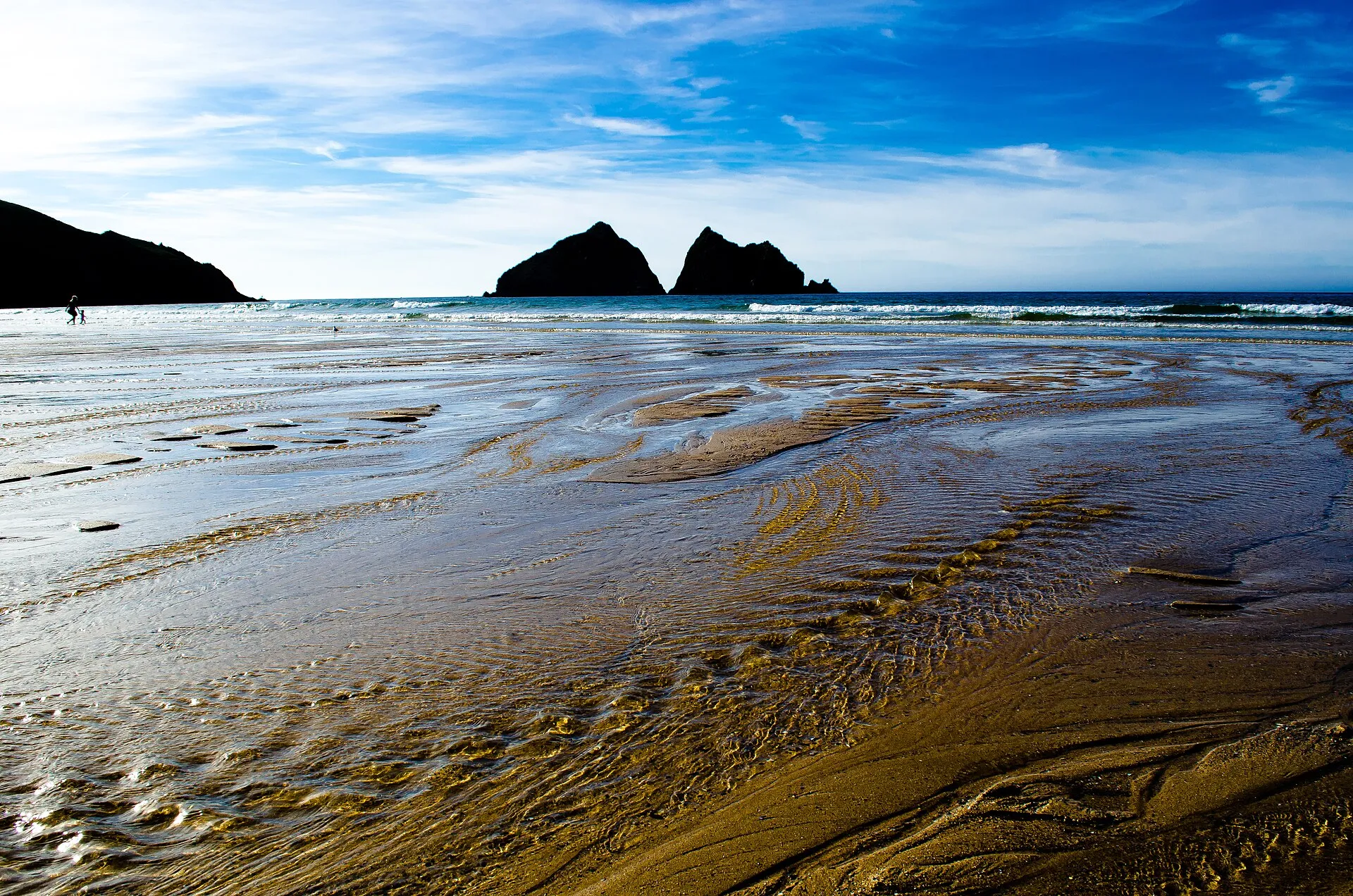 Breiter Sandstrand von Holywell Bay mit den markanten Gull Rocks vor der Küste