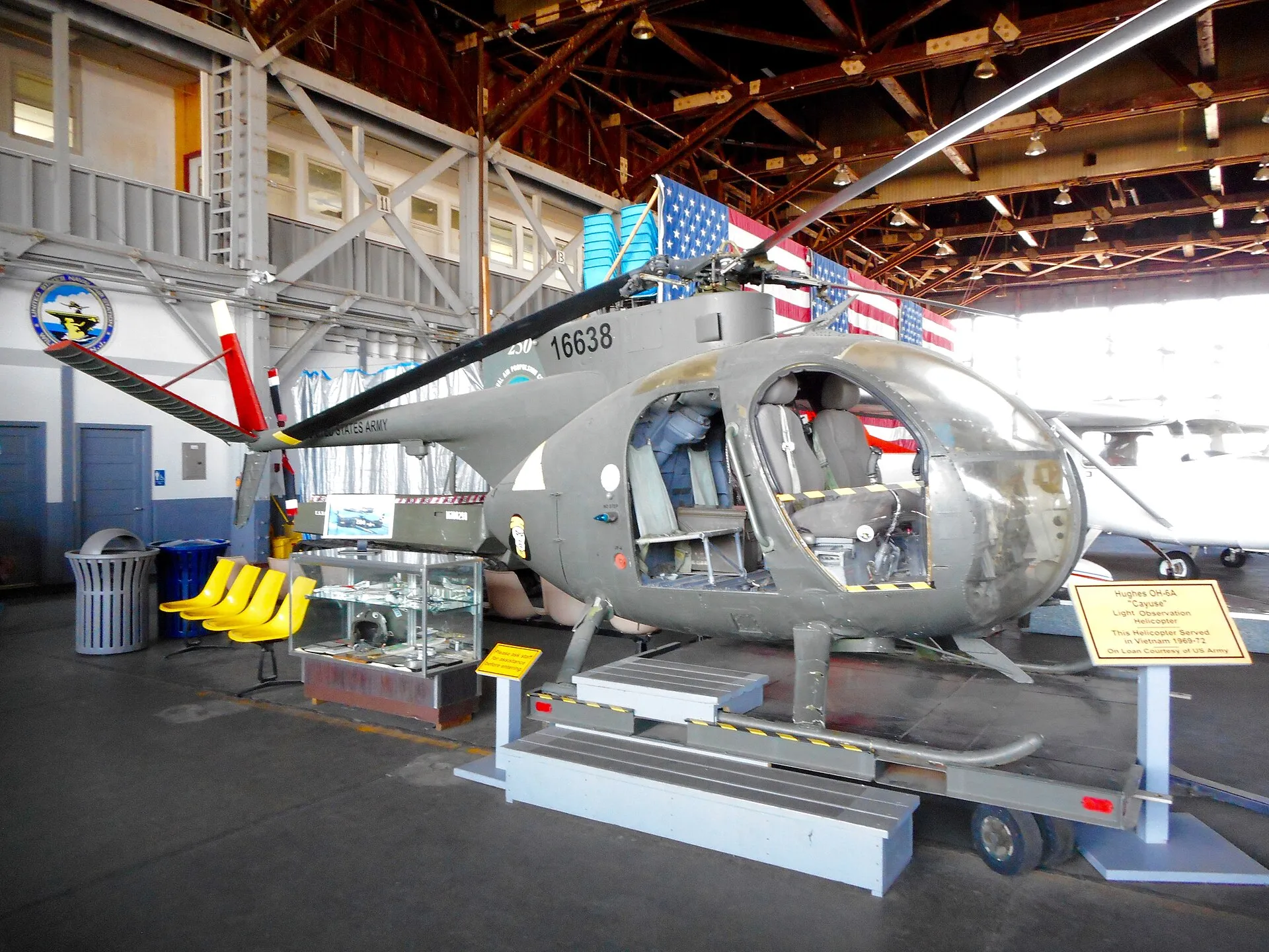 Hughes OH-6A mit kugeliger Glaskanzel in einer Museumshalle.