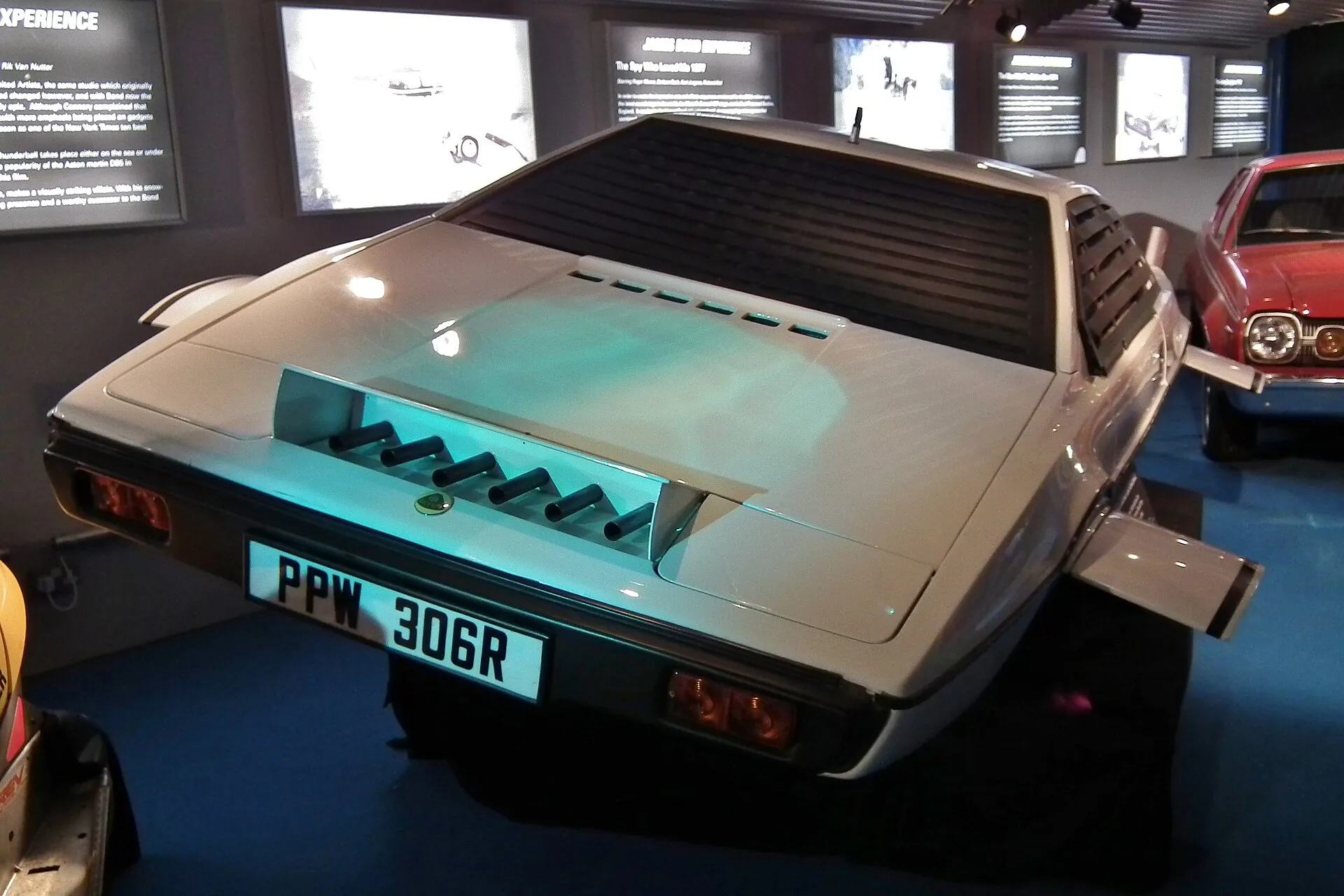 Der zum U-Boot umgebaute weiße Lotus Esprit von schräg hinten in einer Ausstellungshalle, mit ausgefahrenen Leitflächen und dem Kennzeichen PPW 306R