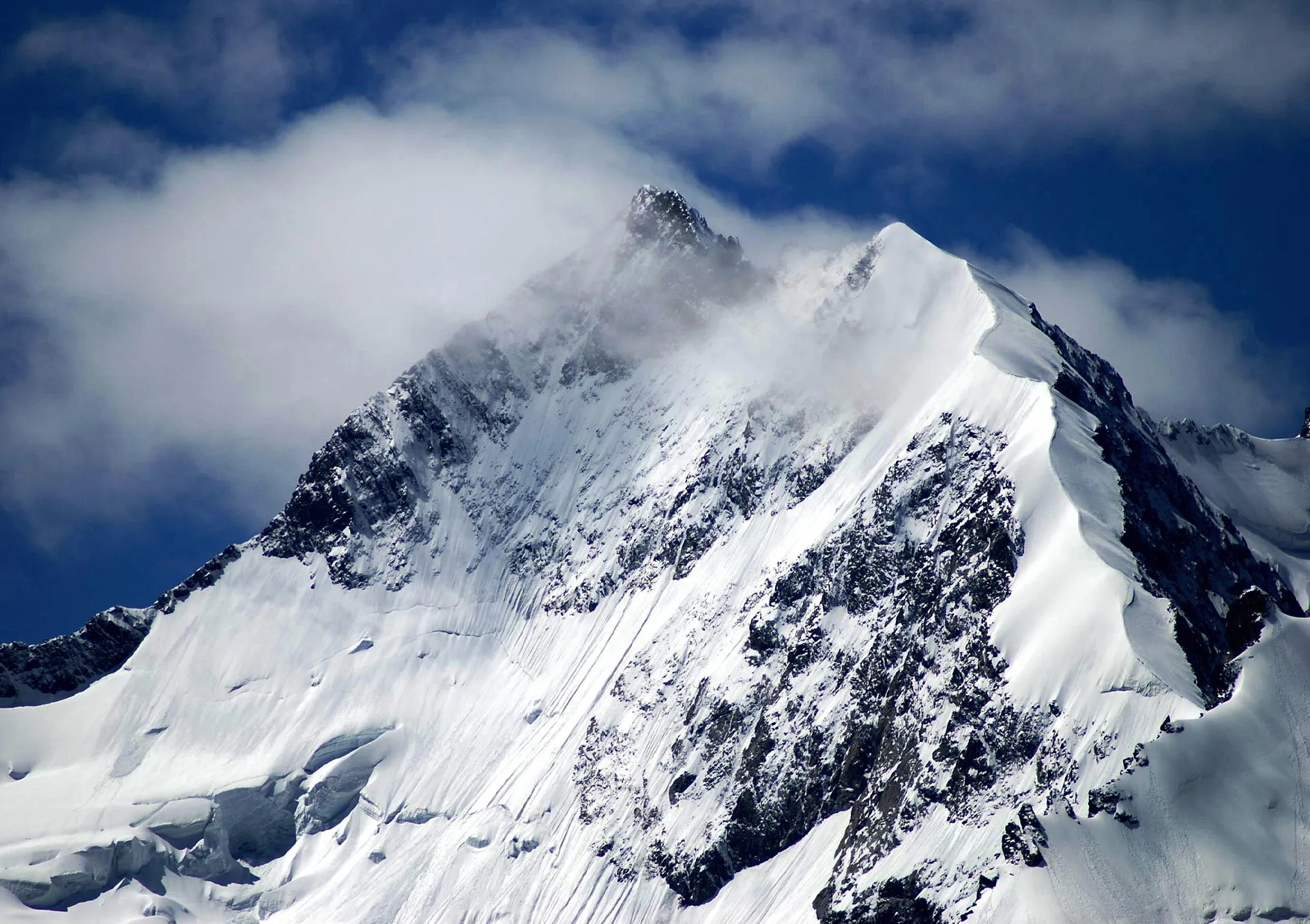 Verschneiter Gipfel des Piz Bernina mit Gletschern und schroffen Graten