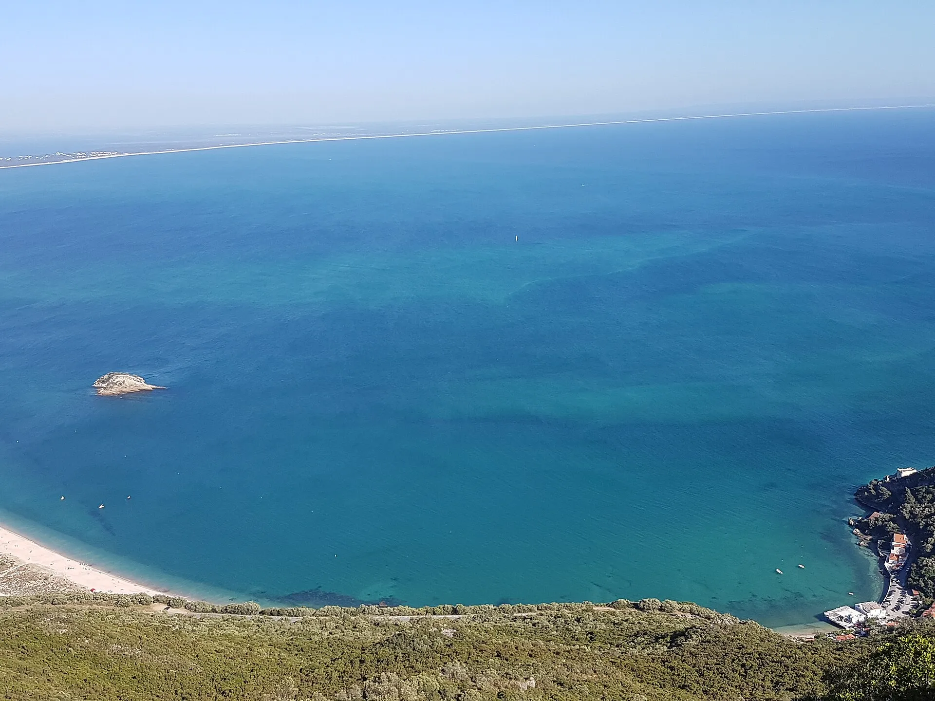 Blick vom Aussichtspunkt der Serra da Arrábida auf die Bucht von Portinho mit türkisem Wasser und langer Sandbank