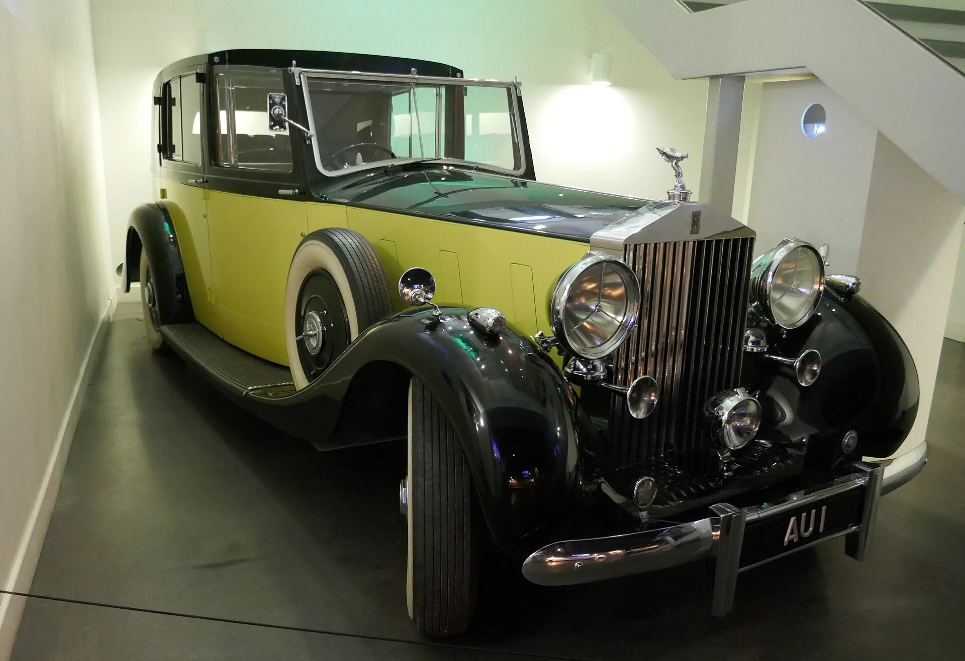 Schwarz-gelber Rolls-Royce Phantom III Sedanca de Ville mit dem Kennzeichen AU 1 in einem Museumsraum