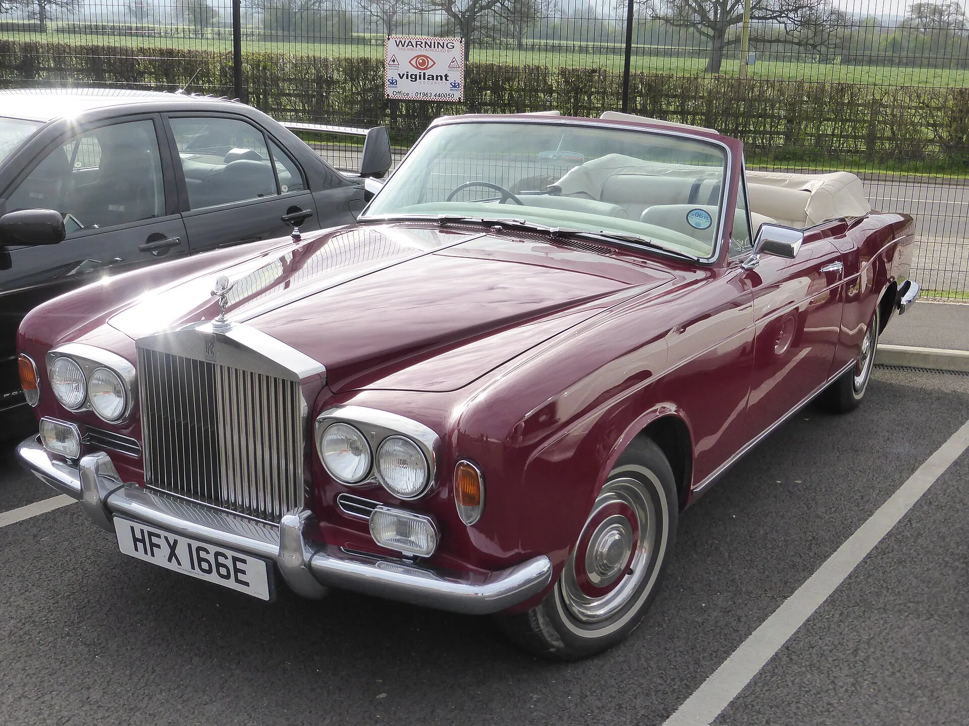 Weinroter Rolls-Royce Silver Shadow Drophead Coupé von 1967 mit offenem Verdeck und heller Lederausstattung auf einem Parkplatz