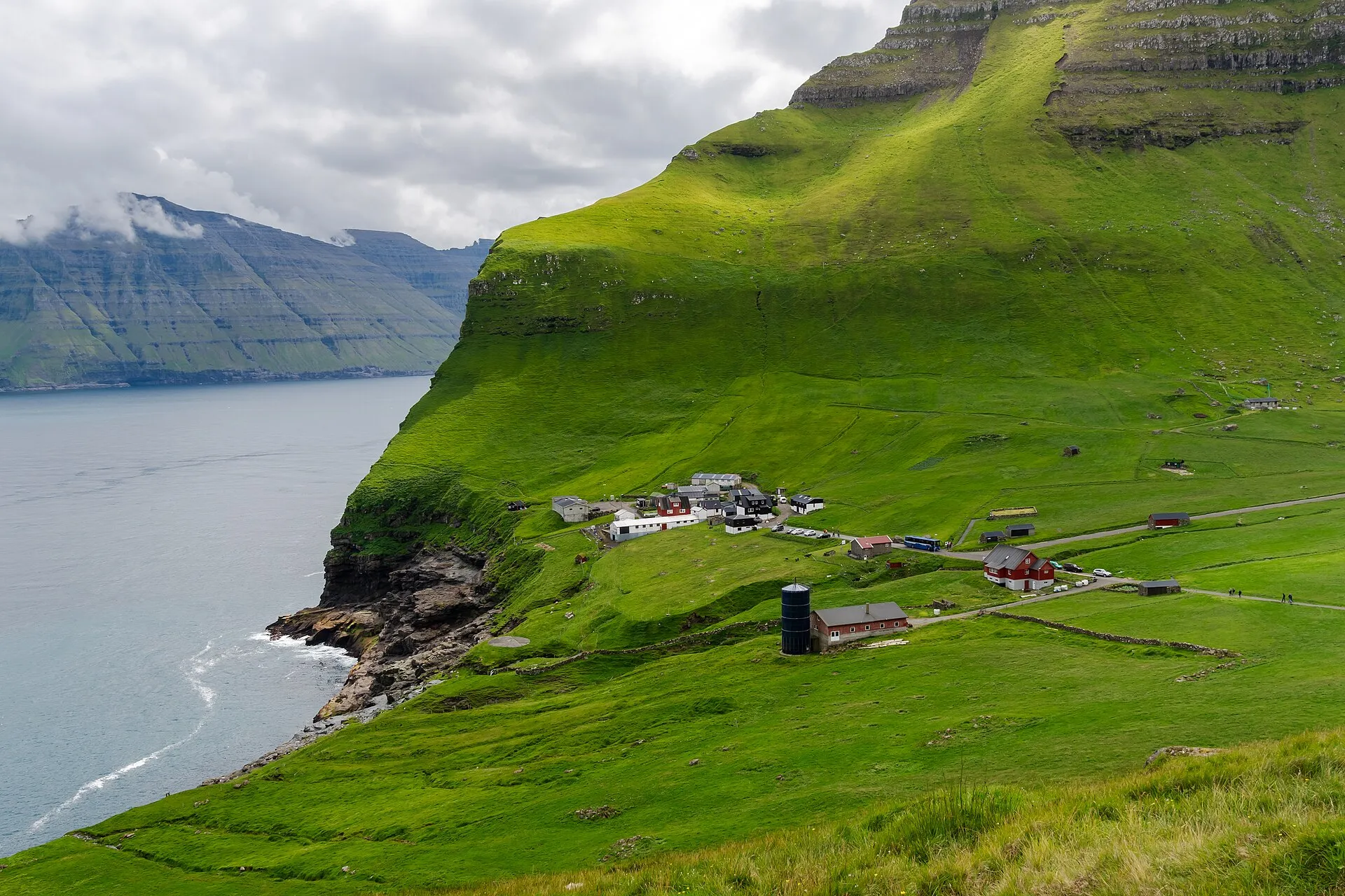 Grüne Steilhänge und das Dorf Trøllanes auf Kalsoy