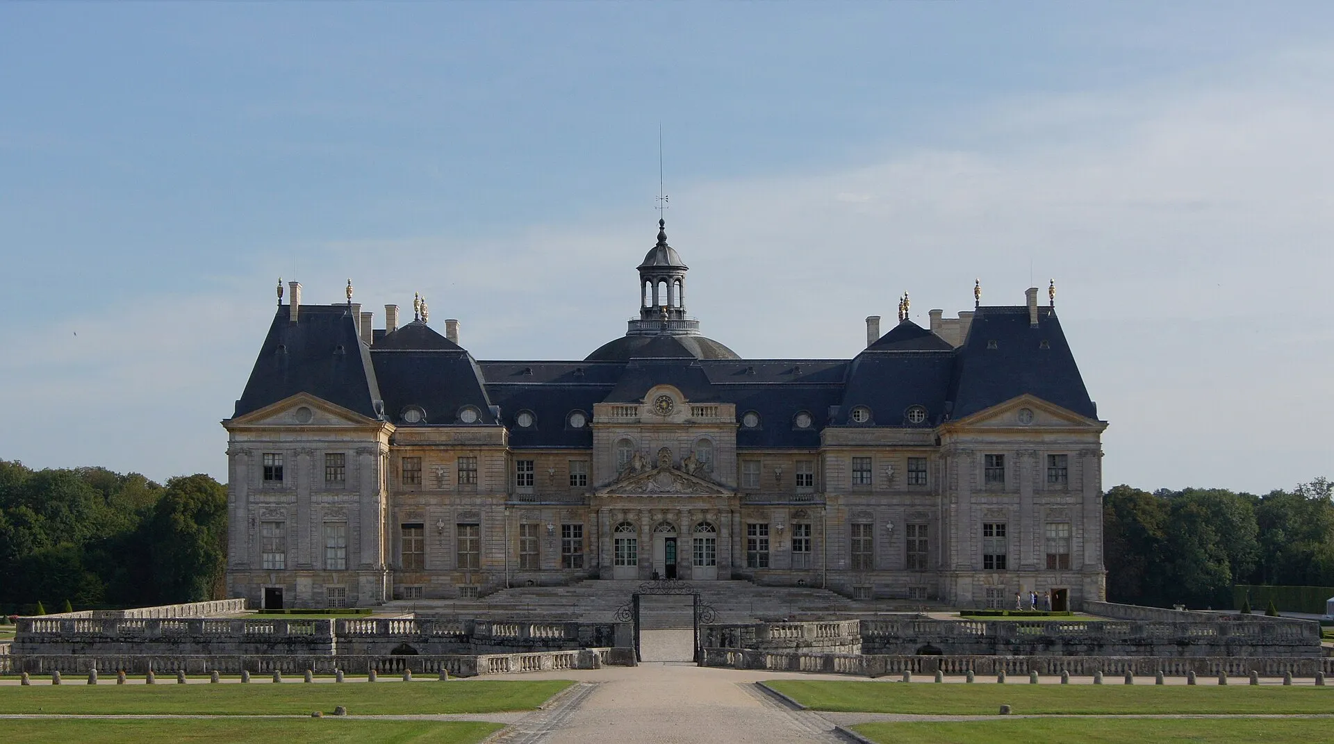 Symmetrische Front des Schlosses Vaux-le-Vicomte hinter Wassergraben und steinerner Brücke
