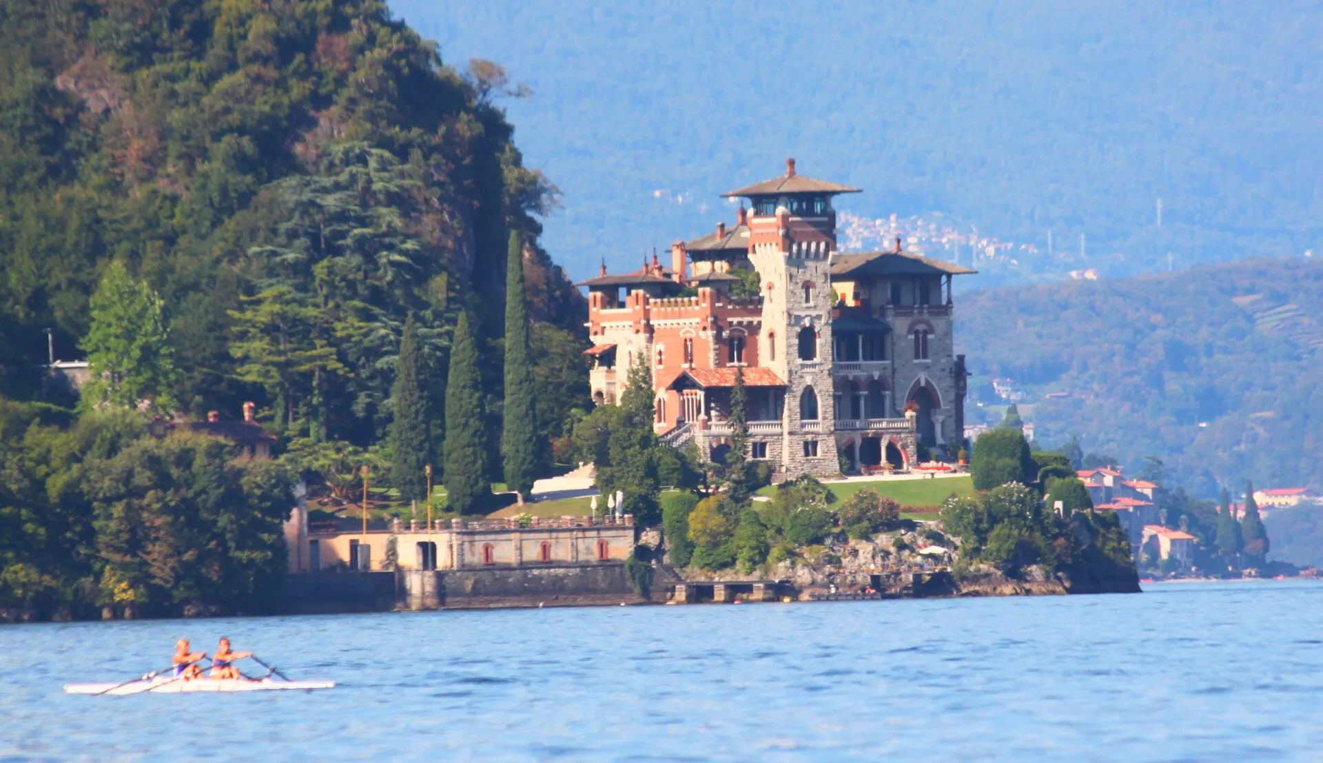 Villa La Gaeta mit Türmen und roter Fassade am Ufer des Comer Sees