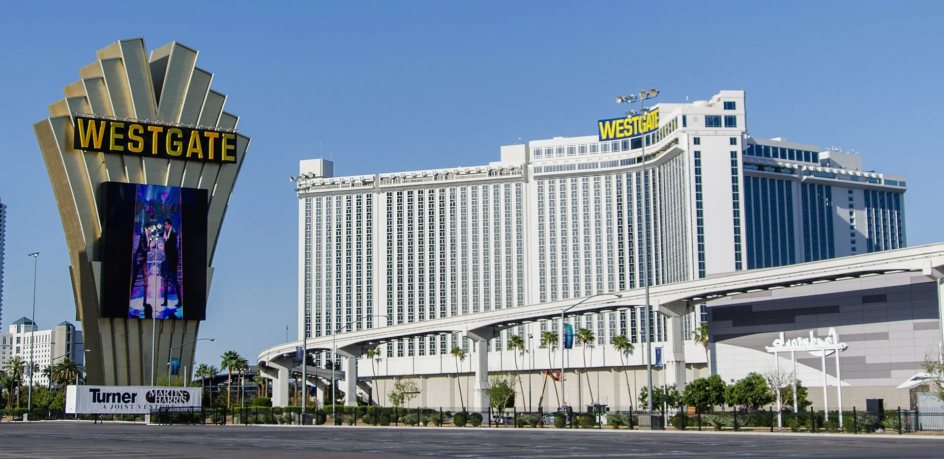 Der weiße Hotelturm des Westgate Las Vegas mit dem großen Leuchtschild an der Straße